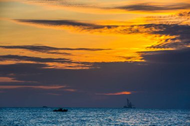 Yüzer petrol platformunda deniz günbatımı. Hainan, Çin.