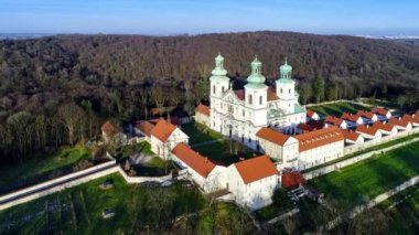 Bielany, Krakow, Polonya, hava 4k video Vistula Nehri ve uzak Cracow şehir içinde belgili tanımlık geçmiş görünümünü ile kışın günbatımı ışıkta Hill'de tahtaya Camaldolese Manastırı ve Barok Kilisesi