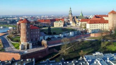 Royal Wawel Kalesi ve Krakov, Polonya, altın kubbesi ile Rönesans Sigismund Şapel ile Gotik Katedrali duvarları, bahçesinde, park ve turistler güçlendirilmiş. Hava 4 k uçuşu kışın gün batımında video.