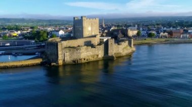Carrickfergus gündoğumu ışık Belfast yakınındaki Ortaçağ Norman kalesi. Hava 4 k uçuşu marina, yatlar, Otopark, kasaba ve uzak Belfast görünümünde arka plan ile video