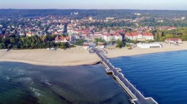 Sopot resort Polonya. Ahşap iskele (Molo) gezinti, Yat Limanı, yat, korsan turist gemisi, beach, eski fener, Spa, otel ve tatil altyapı ile. Hava 4k video güneş doğarken ortaya.