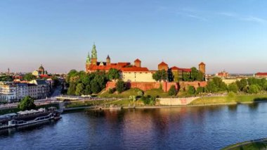 Krakow, Polonya. Wawel royal Castle ve Katedrali, Vistula Nehri, park, gezinti ve yürüyüş insanlar. Cracow içinde belgili tanımlık geçmiş tarihi kiliseler ile eski şehir. Hava 4 k yaklaşım ve bahar günbatımında video uçuşu