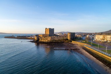 Carrickfergus 'taki Ortaçağ Norman Kalesi. Gün doğumunda Belfast yakınlarında. Marina, yat, dalgakıran, Groyne, tortular ve arka planda Belfast manzaralı hava manzarası