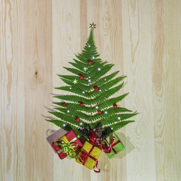 Hoja de helecho verde, como un árbol de Navidad con regalos —  Fotos de Stock