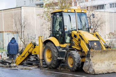 İşçiler bir ekskavatör ile çukur kaz. Yol onarım. 