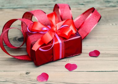 Kırmızı renk bir yay ile şenlikli hediye kutusu. Yalanlar üzerine bir beyaz backgr