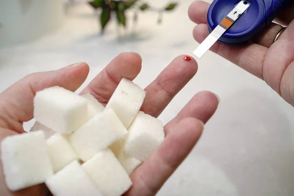 Ein medizinischer Test, bei dem ein Tropfen Blut auf den Zuckerspiegel überprüft wird. — Stockfoto