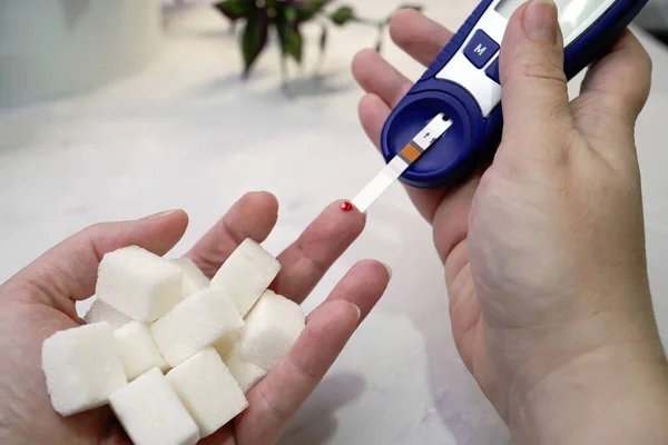 A medical test, checking a drop of blood on the sugar level.