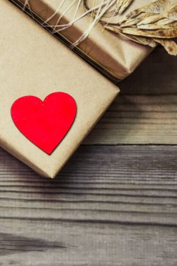Kraft kağıt bir Hediyelik kutu bir dantel ile bağlı. Ahşap bir kırmızı kalp.