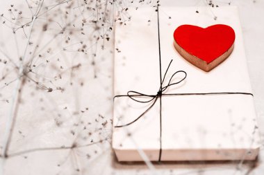 Kraft kağıt bir Hediyelik kutu bir dantel ile bağlı. Ahşap bir kırmızı kalp.