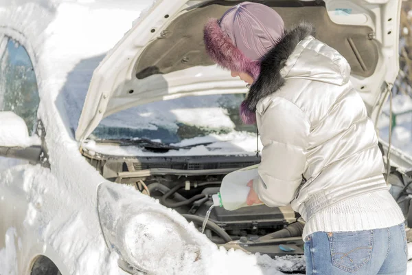 女孩打开汽车的引擎盖并且倾吐了无冰. — 图库照片
