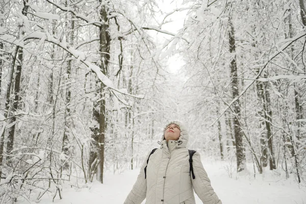 一个女人站在森林里, 抬头仰望。很多雪. — 图库照片