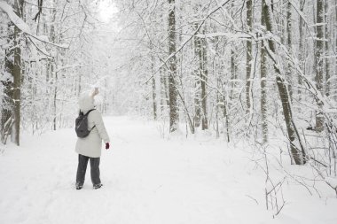 Bir kadın ormanda ayakta ve selfie telefonda yapma.