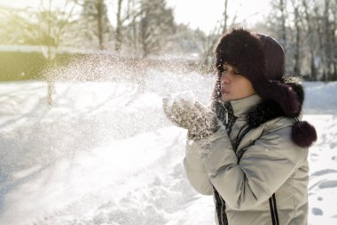 Bir kadın bir avuç kar onun elinde tutan ve üzerinde esiyor. Kablosuz