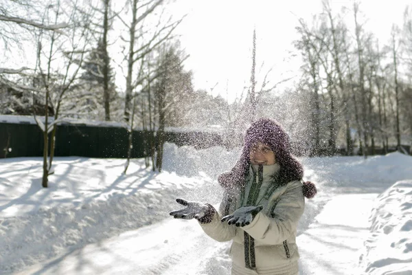 一个女人手里拿着一把雪, 吹着它。无线 — 图库照片