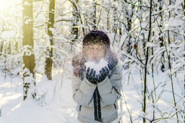 Bir kadın bir avuç kar onun elinde tutan ve üzerinde esiyor. Kablosuz