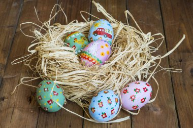 Boyalı yumurta yalan bir sepet, ahşap arka plan, Paskalya
