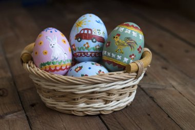 Boyalı yumurta yalan bir sepet, ahşap arka plan, Paskalya