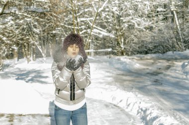 Bir kadın bir avuç kar onun elinde tutan ve üzerinde esiyor. Kablosuz