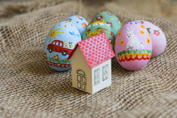 Маленький картонный домик с красной крышей, пасхальные яйца — стоковое фото