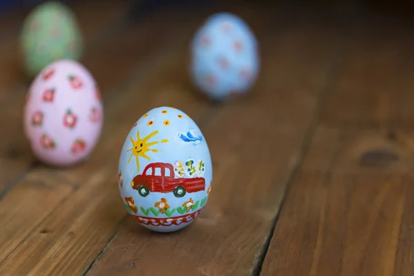 Пасхальное яйцо с машиной на деревянной доске — стоковое фото
