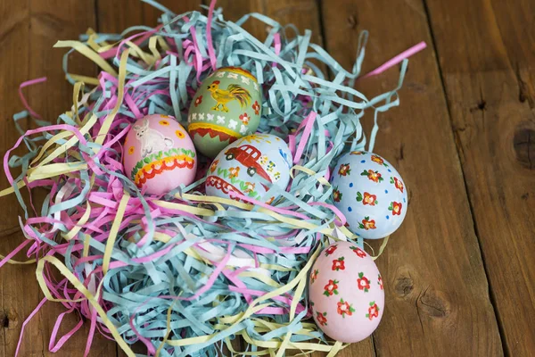 Окрашенные яйца лежат в корзине, деревянный фон, Пасха — стоковое фото