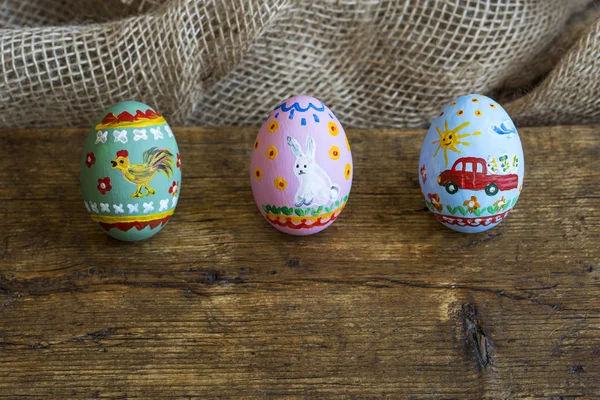 Τρία αυγά Πάσχας σε ένα ξύλινο ταμπλό με — Φωτογραφία Αρχείου
