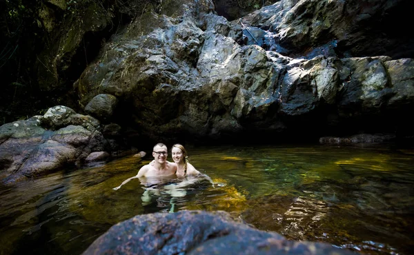 Красивая пара плавает в водопаде — стоковое фото
