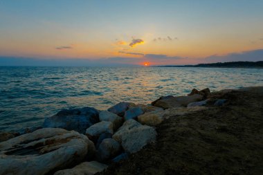 Türkiye 'nin Side kentindeki tropikal plajda altın gün batımlı yaz manzarası. Balayı sırasında cennette çekilmiş tatil fotoğrafları..