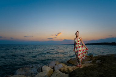 Türkiye 'nin Side kentinde tropikal plajda altın gün batımını izleyen beyaz bir kadınla yaz manzarası. Balayı sırasında cennette çekilmiş tatil fotoğrafları..