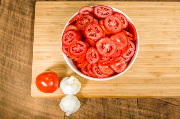 Bowl of sliced tomatoes and garlic — Stock Photo, Image