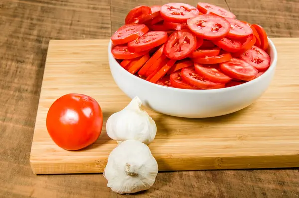 Bowl of sliced tomatoes and garlic — Stock Photo, Image