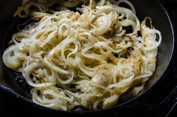 Onions carmaelizing in cast iron skillet — Stock Photo, Image