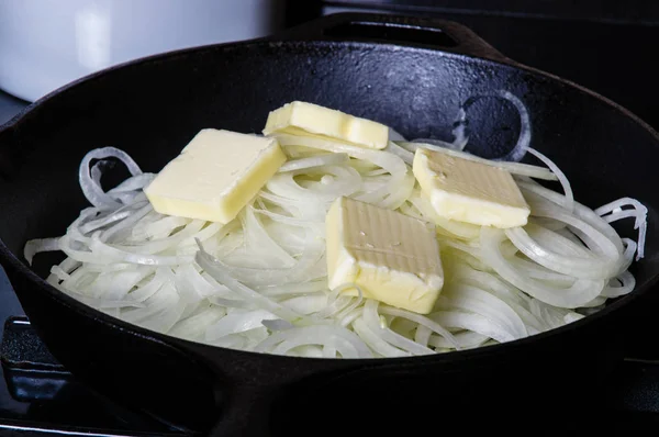 Onions cooking with butter in skillet — Stock Photo, Image