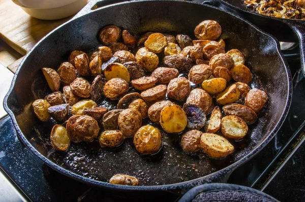 Gesneden aardappelen frituren in gietijzeren koekepan — Stockfoto