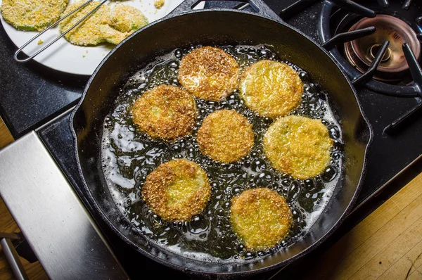 Slices of green tomato being fried — Stock Photo, Image