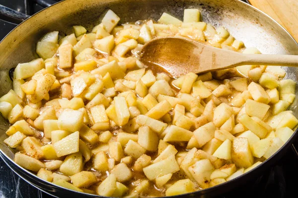 Fresh apples cut up being cooked into sauce