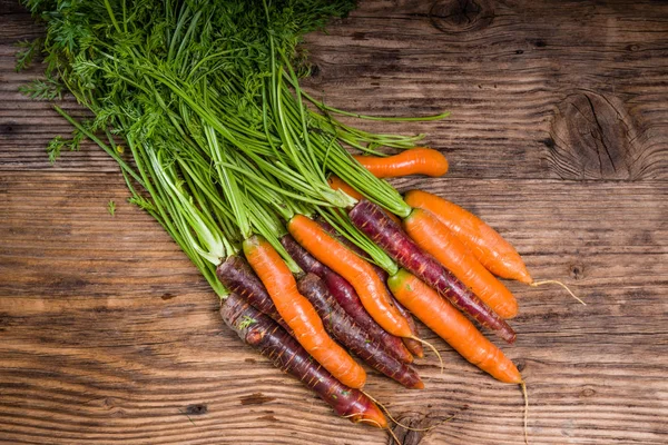 Zanahorias coloridas en una mesa rústica —  Fotos de Stock