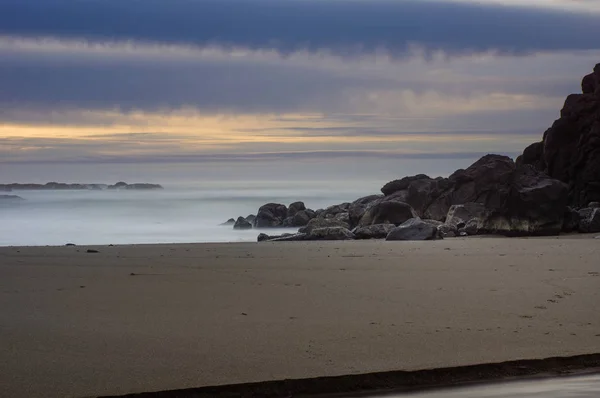 Brume brumeuse au-dessus du surf sur une côte rocheuse — Photo