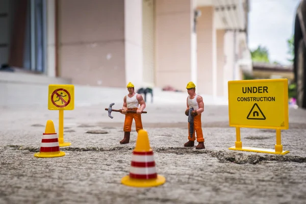 İnşaat uyarı altında sokak onarmak için bakım ekibi kırık, uyarı işareti üzerinde kırık beton sokak ile minyatür resim