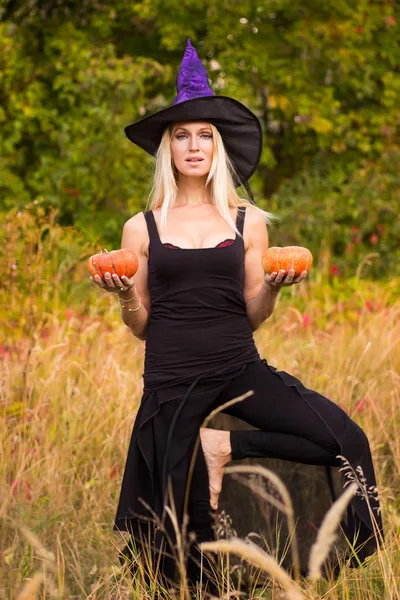 Šťastná žena v kostýmu čarodějnice cvičení jógy — Stock fotografie