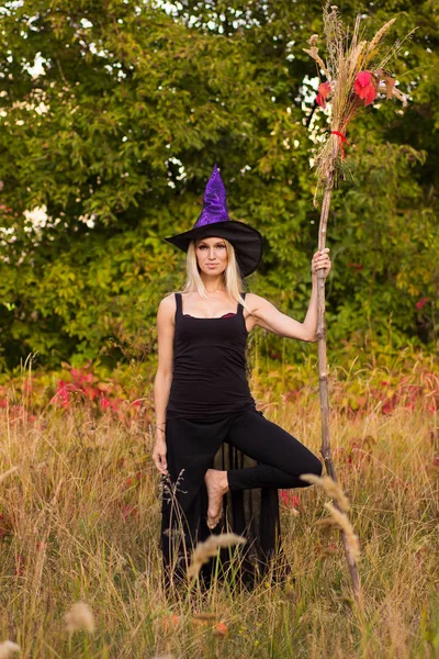 Блондинка в костюме ведьмы практикующая йогу — стоковое фото