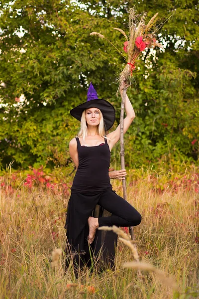 Hezká dívka v kostýmu čarodějnice cvičení jógy — Stock fotografie