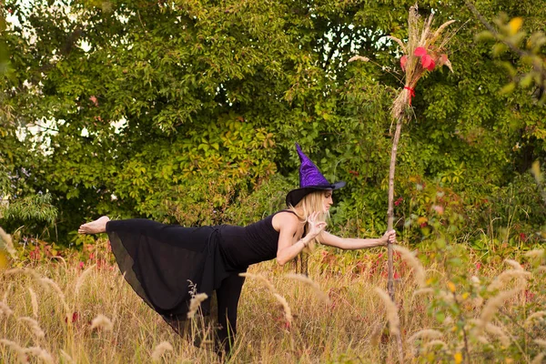 Erwachsenes Mädchen im Hexenkostüm praktiziert Yoga — Stockfoto