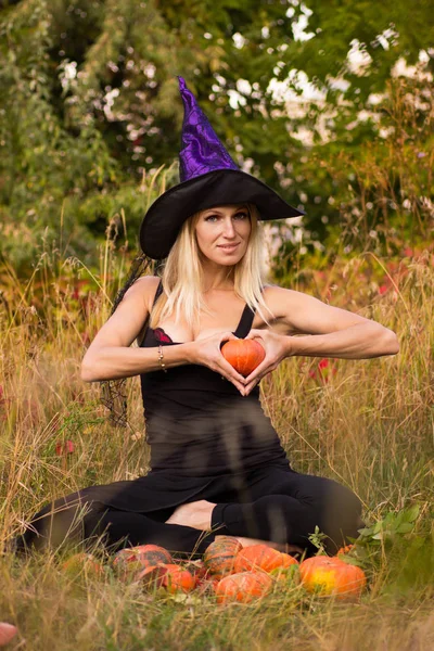 Chica feliz en traje de bruja sentado en pose de loto —  Fotos de Stock