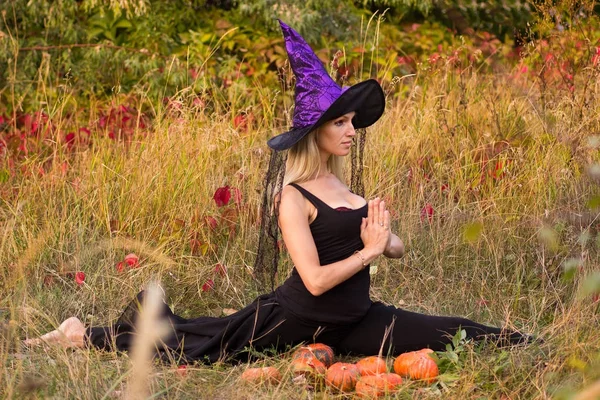 Mujer bonita en traje de bruja practicando yoga —  Fotos de Stock