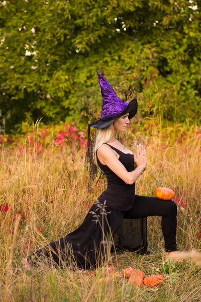 Mulher em traje de bruxa praticando ioga — Fotografia de Stock