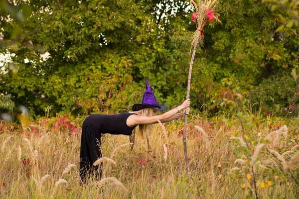 Frohes Mädchen im Hexenkostüm praktiziert Yoga — Stockfoto