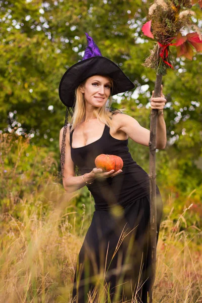 Chica feliz en traje de bruja con palo de escoba —  Fotos de Stock