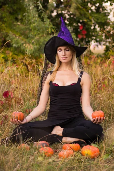 Chica positiva en traje de bruja practicando yoga — Foto de Stock